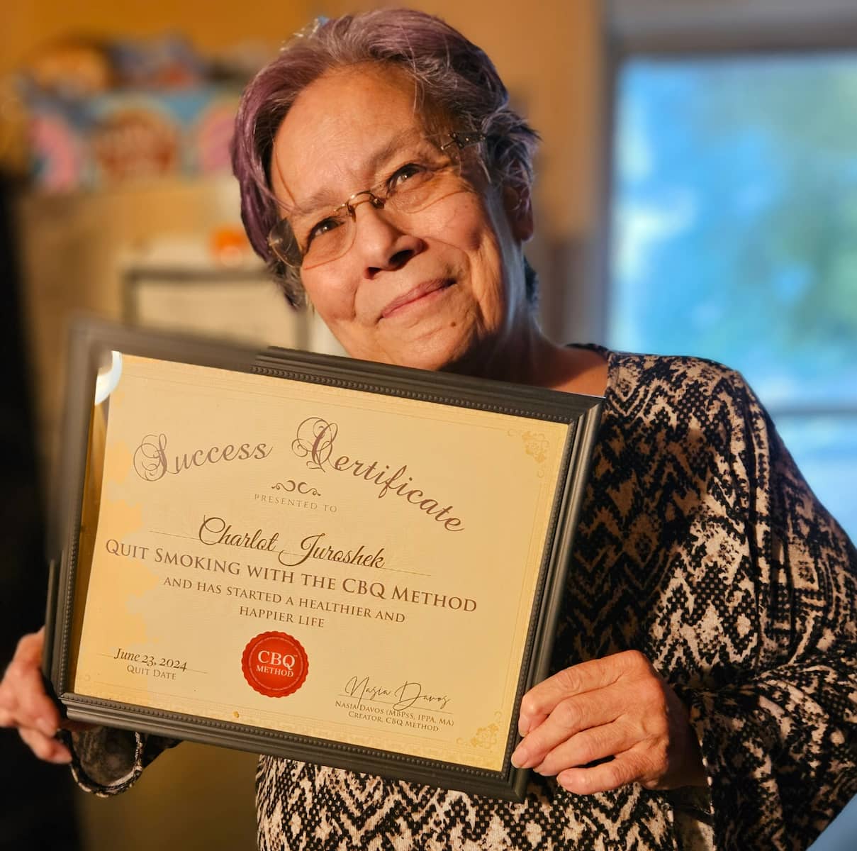 CBQ Nicotine Freedom Program member Charlot Juroshek holding her CBQ Success Certificate