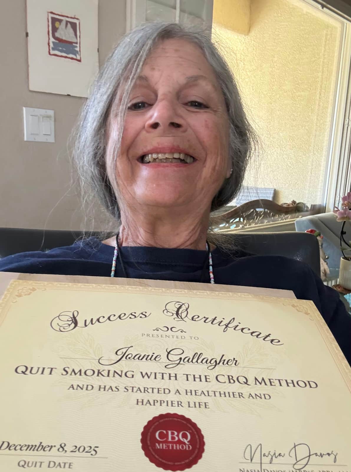 CBQ Nicotine Freedom Program member Joanie Gallagher holding her CBQ Success Certificate