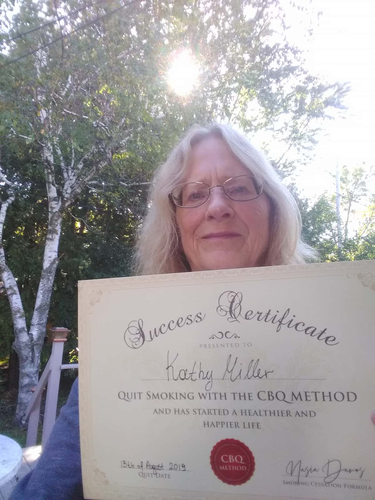 CBQ Nicotine Freedom Program member Kathy Miller holding her CBQ Success Certificate