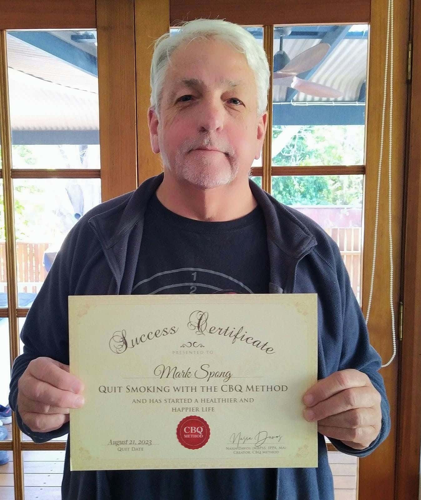 CBQ Nicotine Freedom Program member Mark Spong holding his CBQ Success Certificate